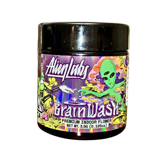 Image of Alien Labs Brainwash strain packaging featuring a jar with the strain name "Brainwash," the brand "Alien Labs," and an alien graphic, all on a transparent background.